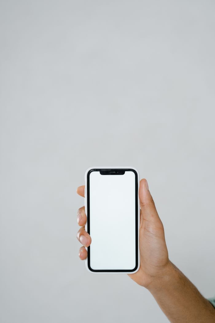 Crafting Captivating Headlines: Your awesome post title goes here A hand holding a smartphone with a blank screen, offering extensive copyspace.